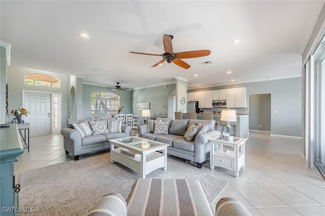 living room with crown molding, light tile patterned floors, and ceiling fan