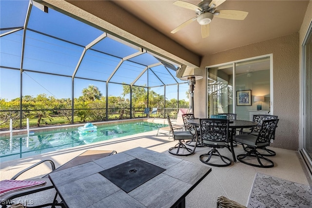 view of pool with ceiling fan, a patio, and glass enclosure