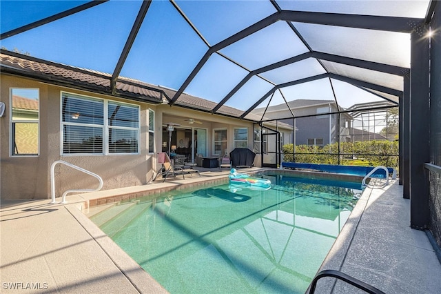 view of pool featuring a lanai, ceiling fan, and a patio area