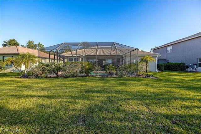 back of house with a yard and a lanai