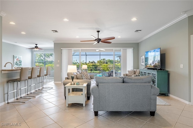 living room with ceiling fan, ornamental molding, and light tile patterned floors