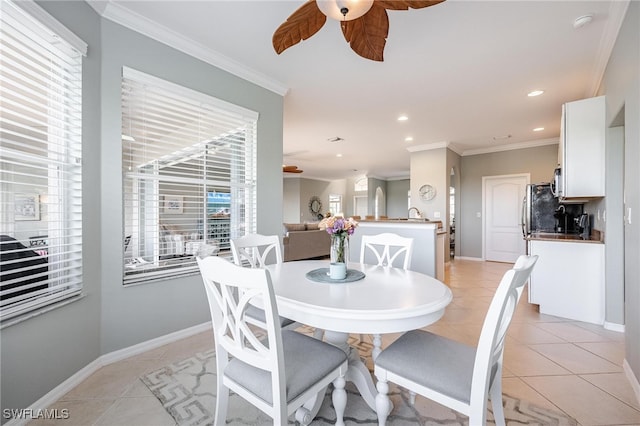 dining space with ceiling fan, light tile patterned flooring, and ornamental molding