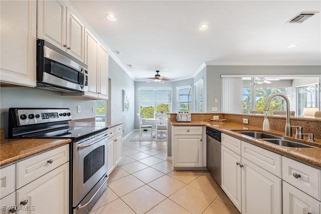 kitchen featuring a healthy amount of sunlight, white cabinetry, sink, and stainless steel appliances