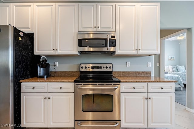 kitchen with white cabinets, stainless steel appliances, and light tile patterned floors