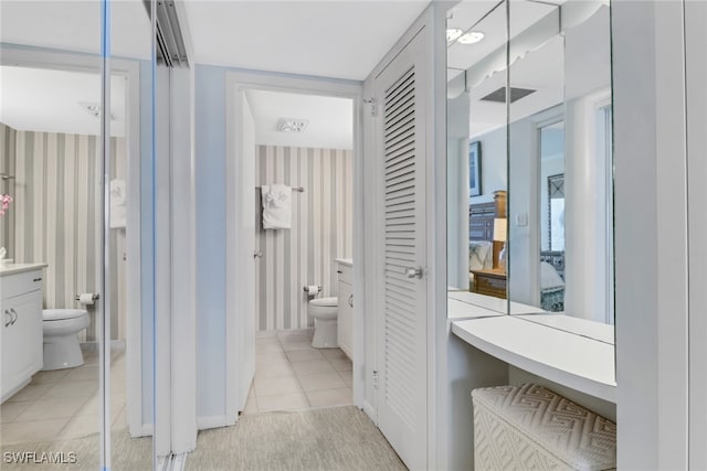 bathroom featuring tile patterned flooring, vanity, and toilet