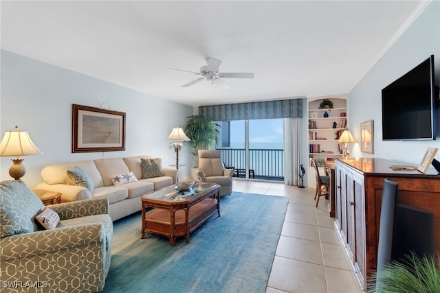 living room featuring tile patterned flooring, ceiling fan, and crown molding