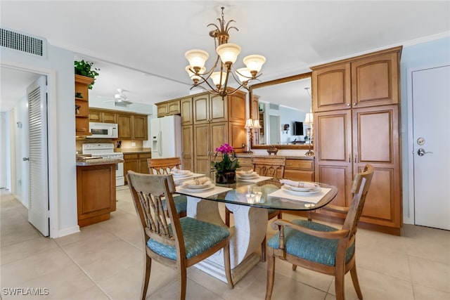 dining room with light tile patterned floors, ceiling fan with notable chandelier, and crown molding