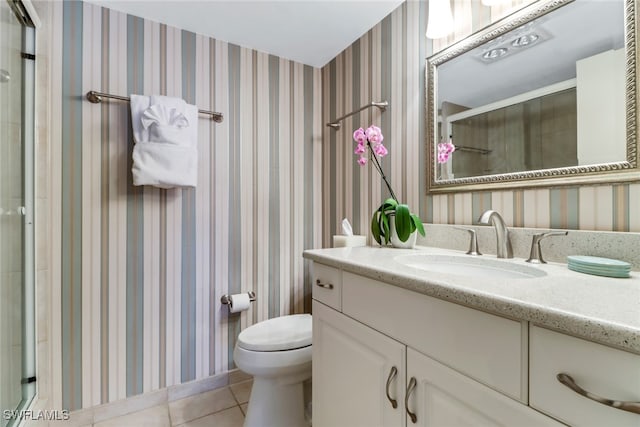 bathroom with tile patterned flooring, vanity, toilet, and walk in shower