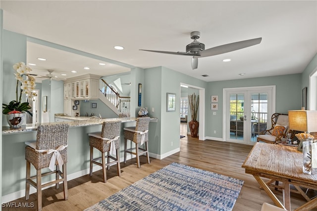 interior space featuring light wood finished floors, recessed lighting, ceiling fan, light stone countertops, and baseboards