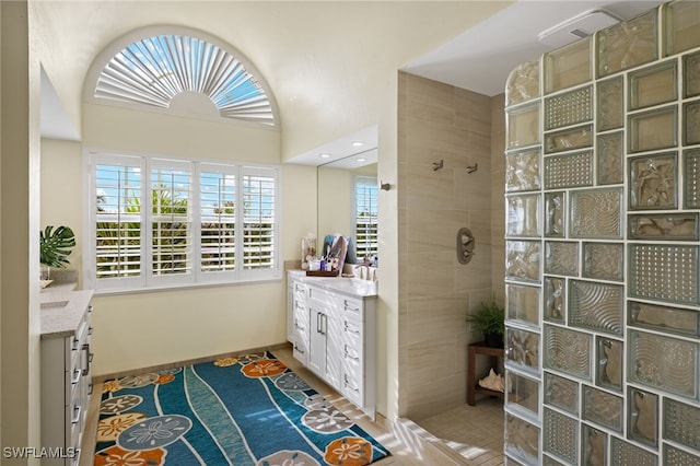 bathroom with tile patterned flooring, walk in shower, and vanity