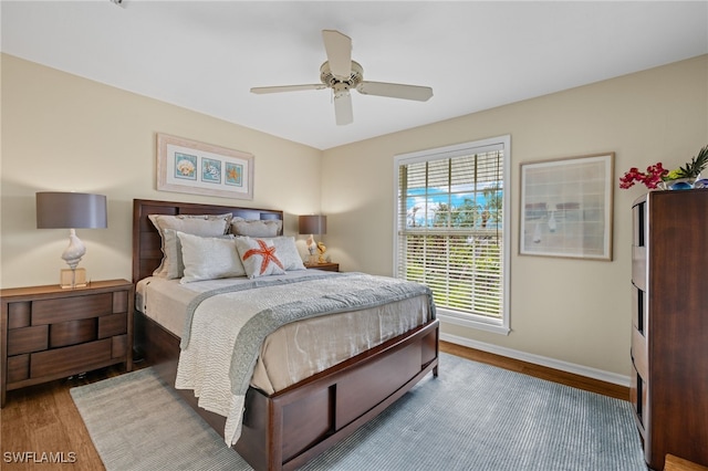 bedroom featuring wood finished floors, a ceiling fan, and baseboards