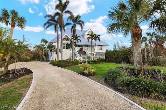 view of front of property with driveway, a porch, stairway, and a front lawn