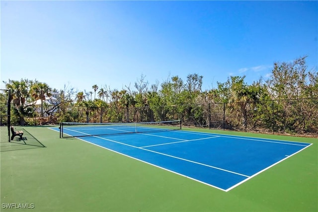 view of tennis court featuring fence