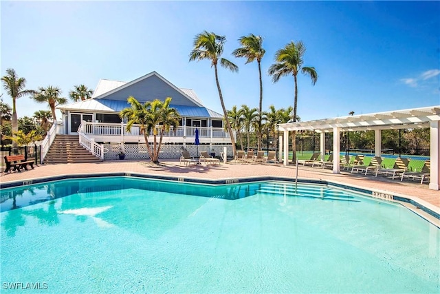 community pool with a sunroom, stairs, a pergola, and a patio