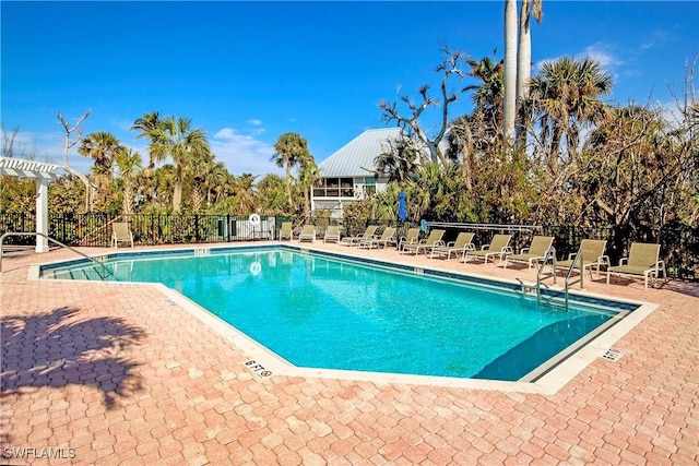 community pool with fence and a patio