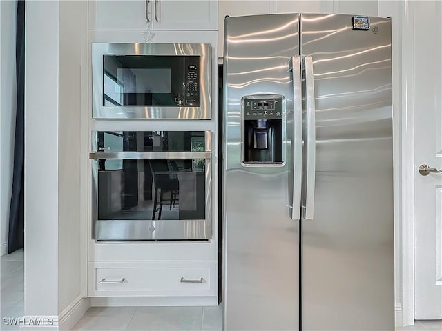 kitchen featuring stainless steel appliances, white cabinetry, and light tile patterned flooring