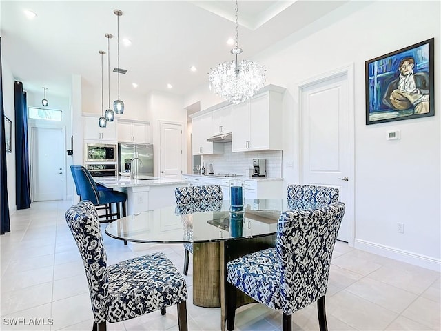 dining room featuring sink, an inviting chandelier, and light tile patterned flooring