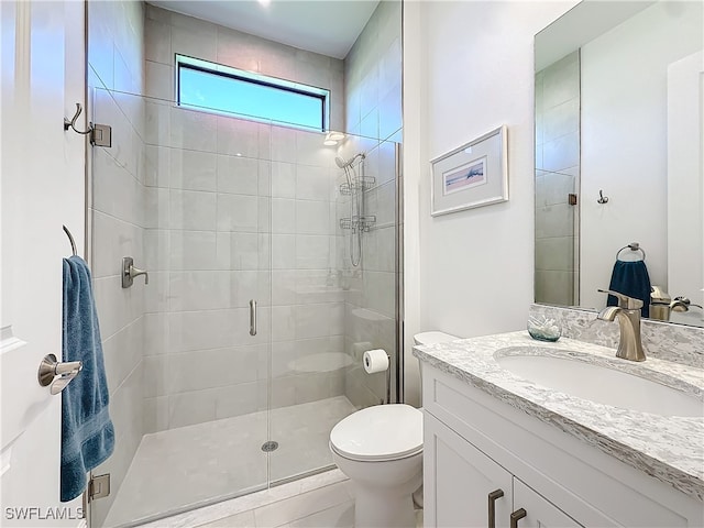 bathroom with tile patterned flooring, vanity, toilet, and a shower with door