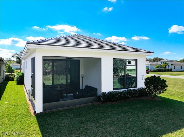 rear view of house featuring a sunroom and a yard