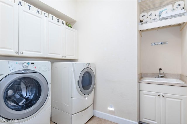 laundry room with washer and dryer, cabinets, light tile patterned floors, and sink