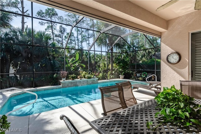 view of swimming pool featuring glass enclosure and a patio area