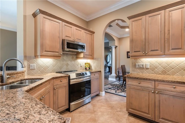 kitchen featuring ornate columns, sink, stainless steel appliances, light stone counters, and crown molding