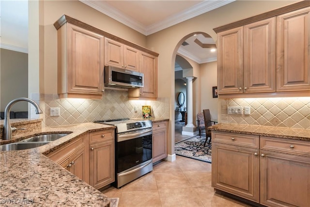 16144 Parque Ln, Naples, FL 34110 - kitchen with stainless steel appliances, a sink, arched walkways, light stone counters, and ornamental molding
