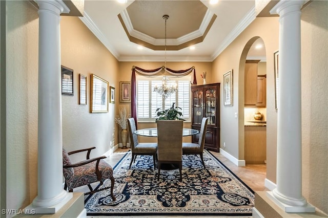 dining room featuring a chandelier, a raised ceiling, and ornamental molding