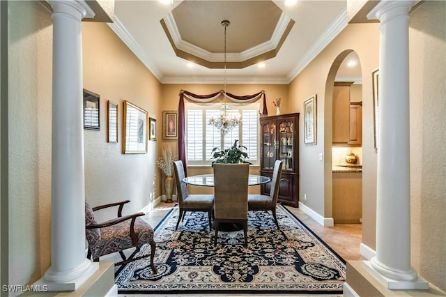 16144 Parque Ln, Naples, FL 34110 - dining space featuring a raised ceiling, arched walkways, crown molding, ornate columns, and a chandelier