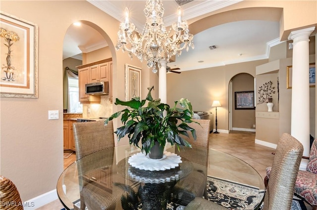 dining space featuring ceiling fan with notable chandelier, ornate columns, and crown molding