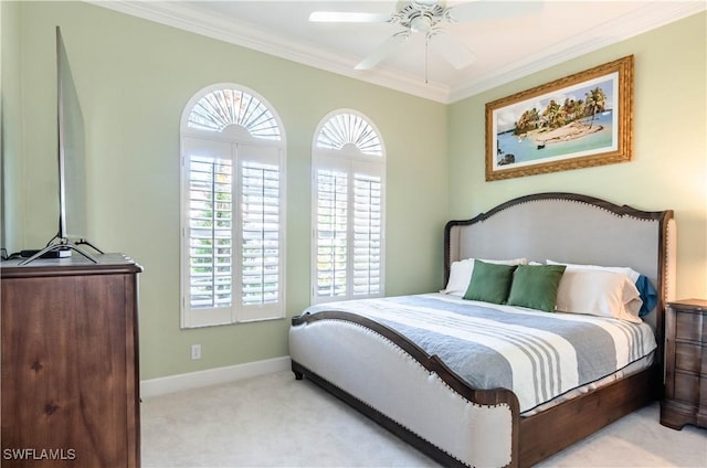 carpeted bedroom featuring ceiling fan and crown molding