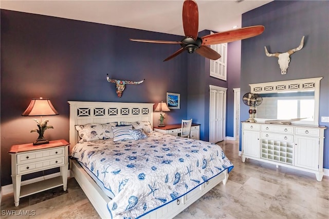 bedroom featuring ceiling fan and a towering ceiling