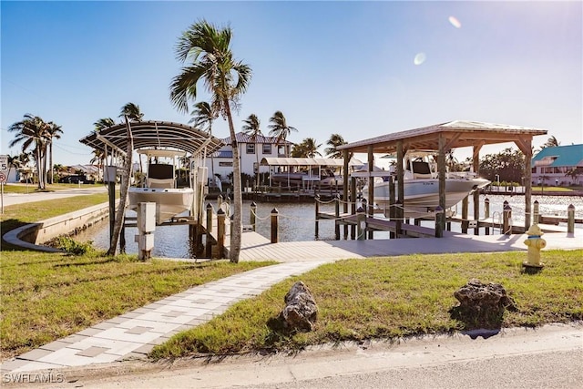 view of dock with a water view and a lawn