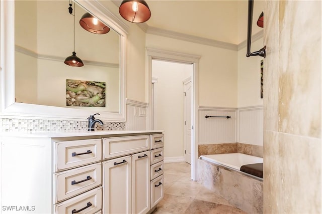 bathroom with vanity, crown molding, and tiled bath