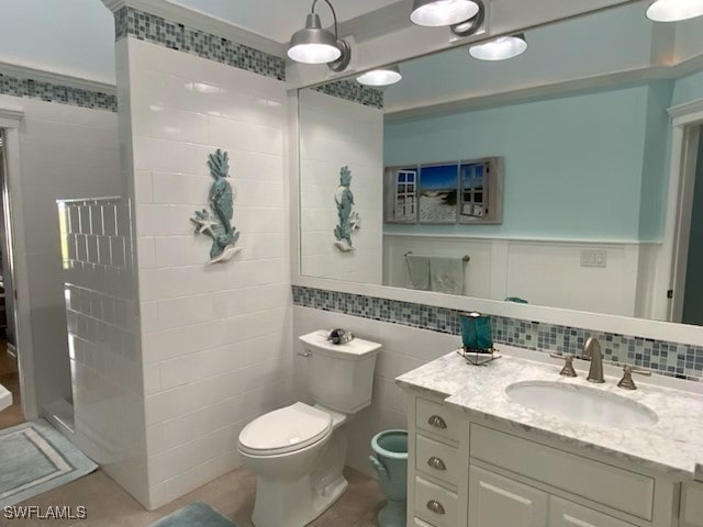 bathroom featuring vanity, tile walls, toilet, and walk in shower