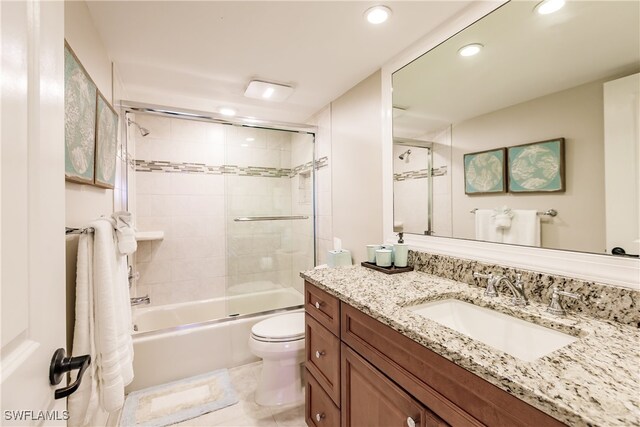 full bathroom featuring tile patterned floors, vanity, toilet, and shower / bath combination with glass door