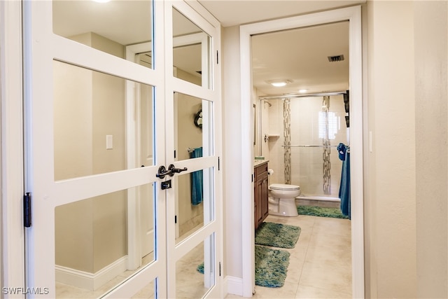 bathroom featuring tile patterned flooring, toilet, an enclosed shower, and vanity