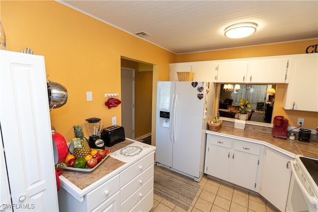 kitchen with white appliances, white cabinetry, and light tile patterned floors