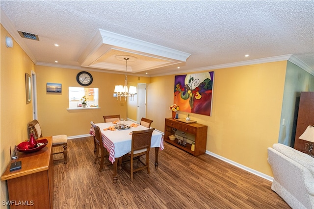 dining room with a textured ceiling, wood-type flooring, crown molding, and an inviting chandelier