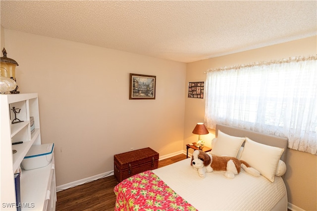 bedroom with dark wood-type flooring and a textured ceiling