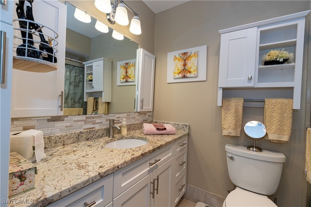 bathroom with backsplash, vanity, and toilet