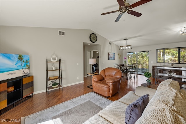 living room featuring ceiling fan with notable chandelier, hardwood / wood-style flooring, lofted ceiling, and sink