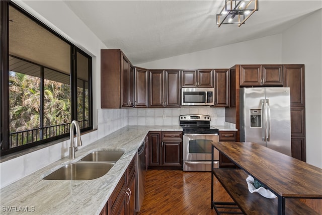 kitchen featuring light stone countertops, sink, stainless steel appliances, tasteful backsplash, and lofted ceiling