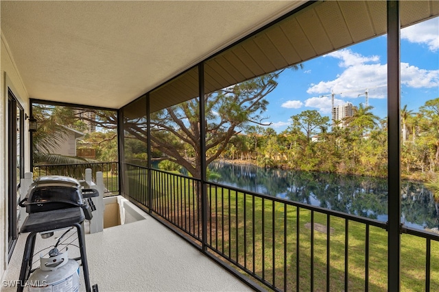 sunroom featuring a water view