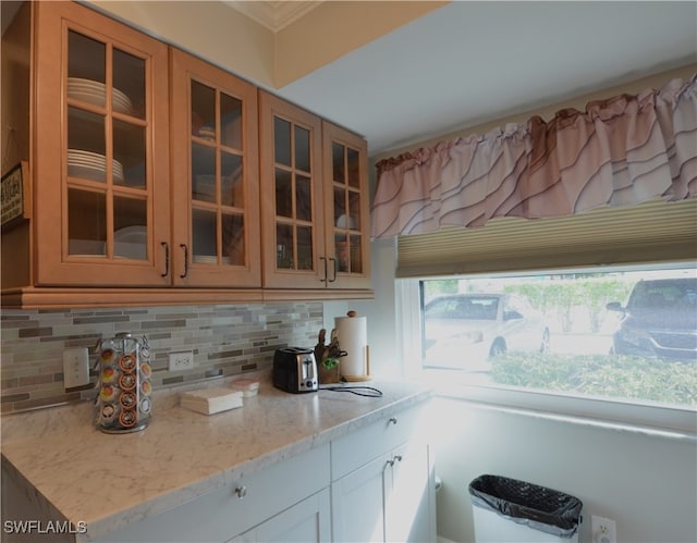 kitchen featuring backsplash, white cabinetry, and light stone counters