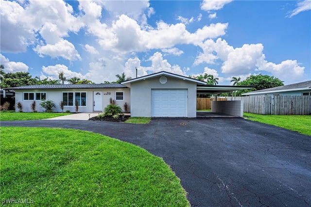 ranch-style home with a carport, a garage, and a front lawn