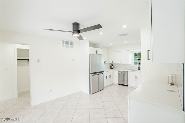 kitchen with ceiling fan, sink, stainless steel appliances, white cabinets, and light tile patterned flooring