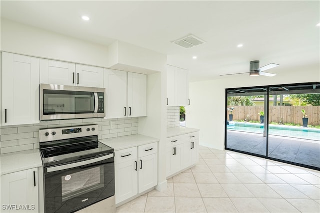 kitchen with appliances with stainless steel finishes, white cabinetry, and ceiling fan