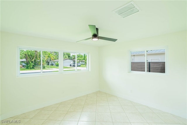 tiled spare room featuring ceiling fan