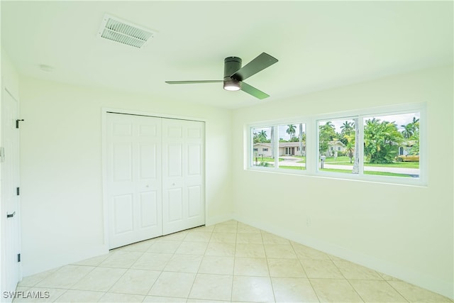 unfurnished bedroom featuring light tile patterned floors, a closet, and ceiling fan